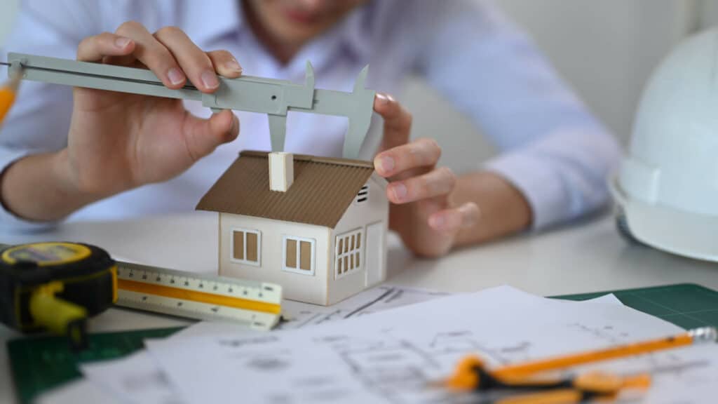 Un homme qui fait des calcules et des travaux sur sa maison