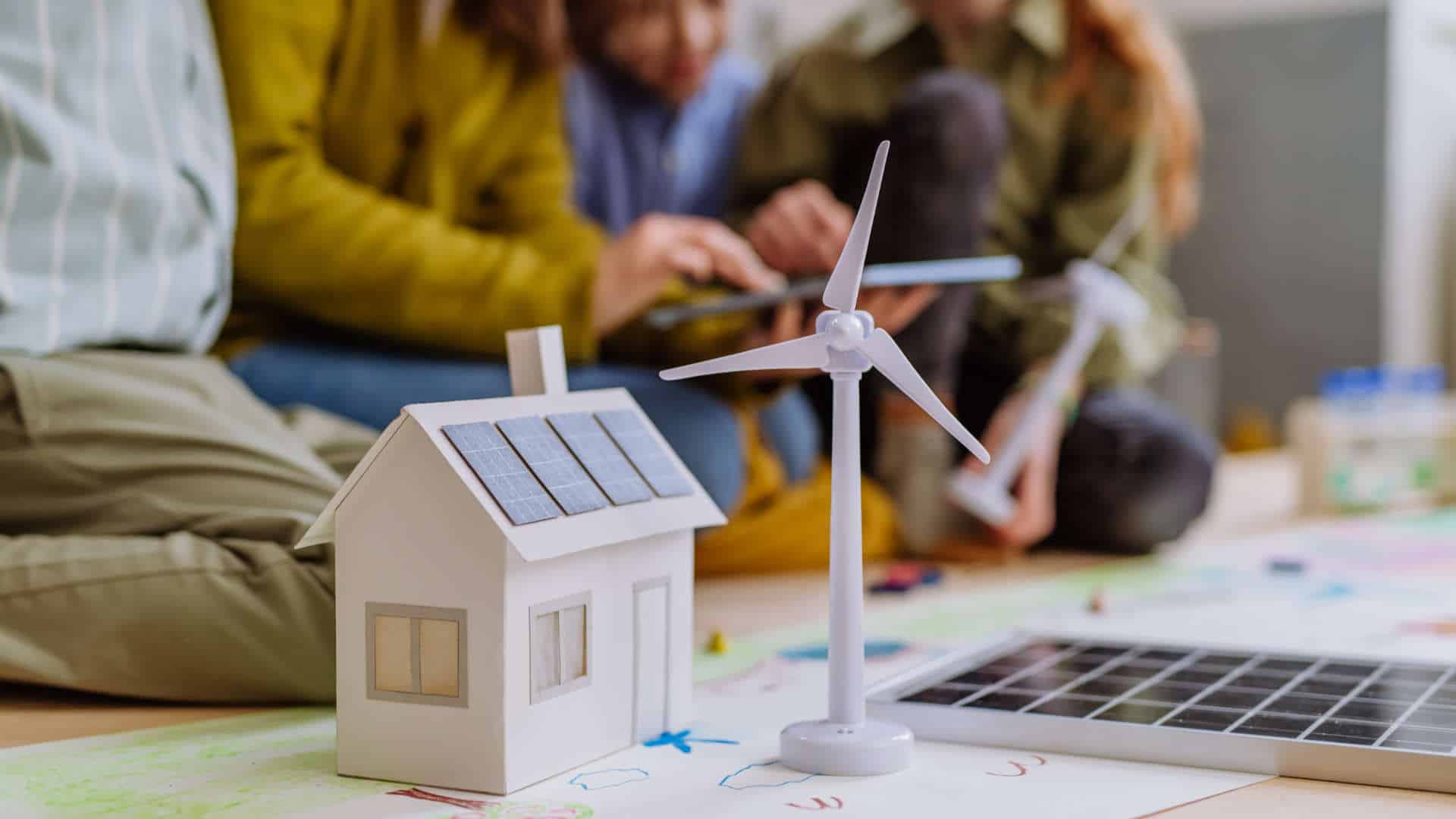 Photo d'une maquette de maison avec des gens autours d'elle