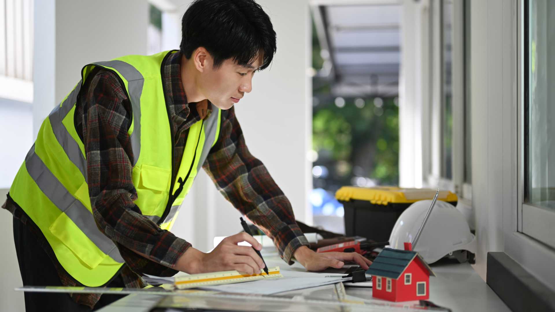 Photo d'un homme qui travail et réalise des calculs dans une maison