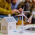 Photo d'une maquette de maison avec des gens autours d'elle