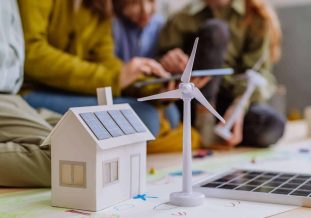 Photo d'une maquette de maison avec des gens autours d'elle